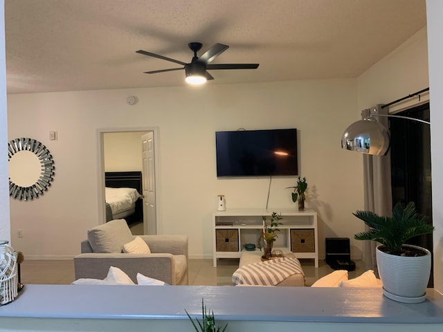 living room with light tile patterned floors, a textured ceiling, and ceiling fan