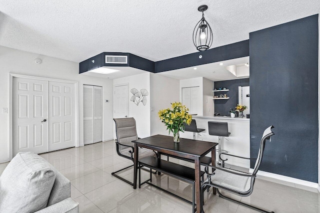 dining room with light tile patterned floors and a textured ceiling