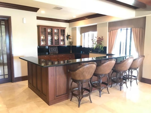 bar featuring ornamental molding and plenty of natural light