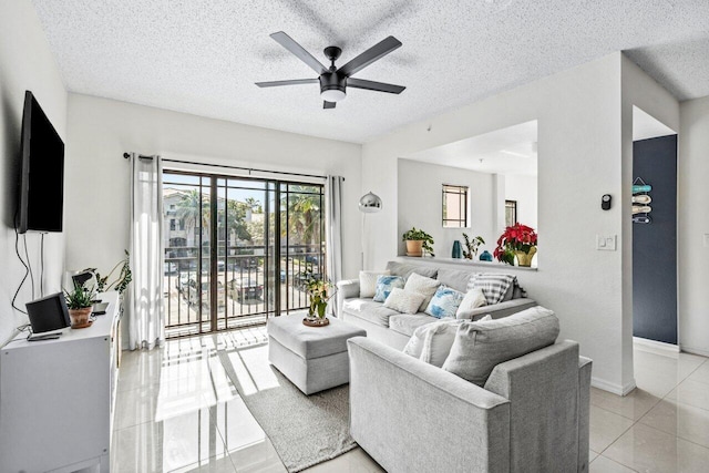 living room featuring ceiling fan, a textured ceiling, and light tile patterned floors