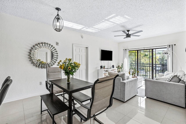 tiled dining room with ceiling fan and a textured ceiling