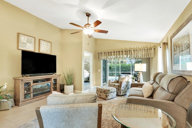 living room with ceiling fan, vaulted ceiling, and light tile patterned floors