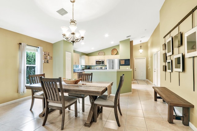 dining room featuring vaulted ceiling, light tile patterned floors, and an inviting chandelier