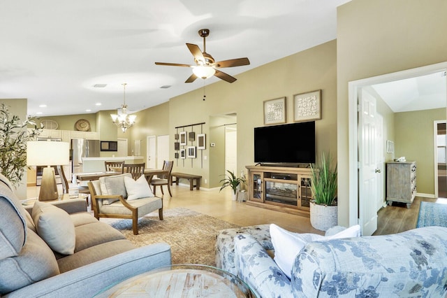 living room with lofted ceiling, ceiling fan with notable chandelier, and light wood-type flooring