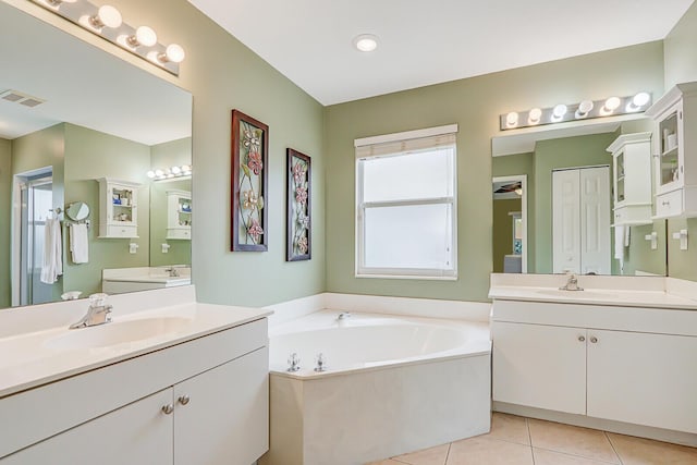 bathroom featuring tile patterned floors, a bathing tub, and vanity