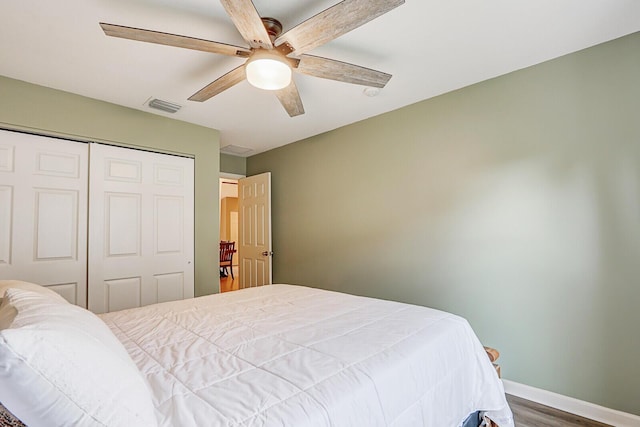 bedroom with ceiling fan, wood-type flooring, and a closet