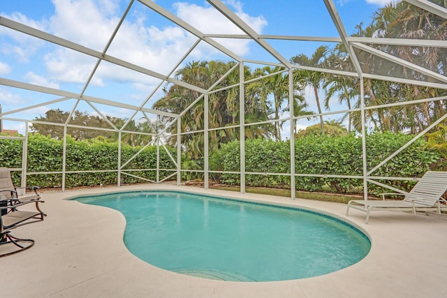 view of swimming pool with a patio and glass enclosure