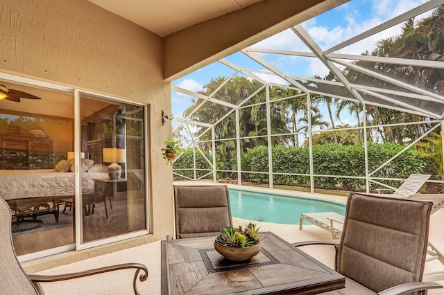 view of swimming pool featuring a patio and glass enclosure