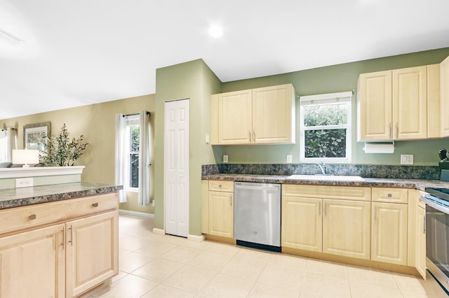 kitchen featuring light tile patterned flooring, appliances with stainless steel finishes, sink, and a wealth of natural light