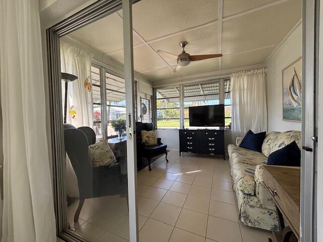 living room featuring tile patterned floors and ceiling fan