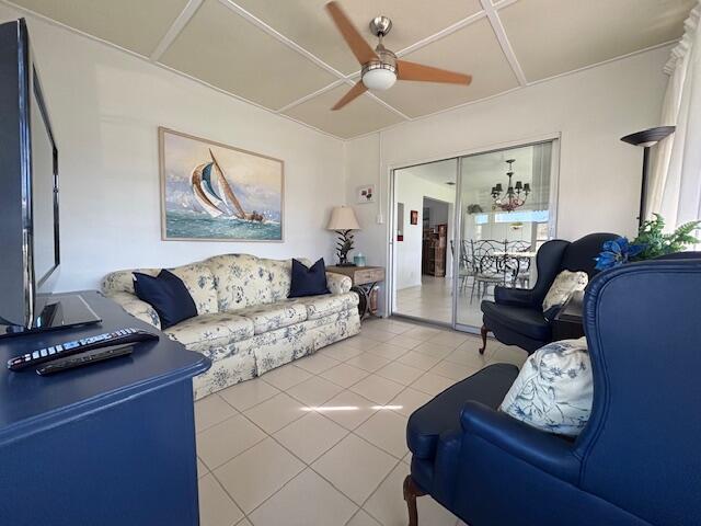 living room with ceiling fan and tile patterned floors