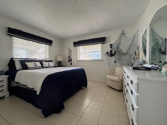 tiled bedroom featuring a textured ceiling