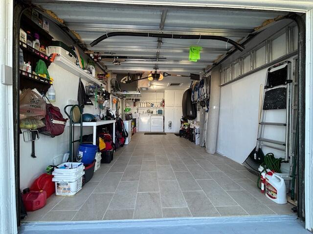 garage with a garage door opener and separate washer and dryer