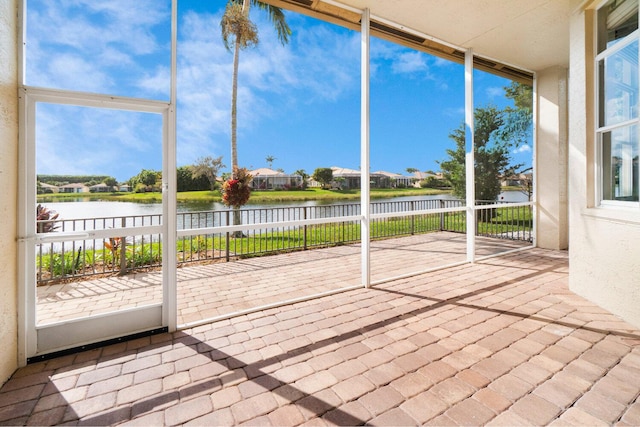 unfurnished sunroom featuring a water view