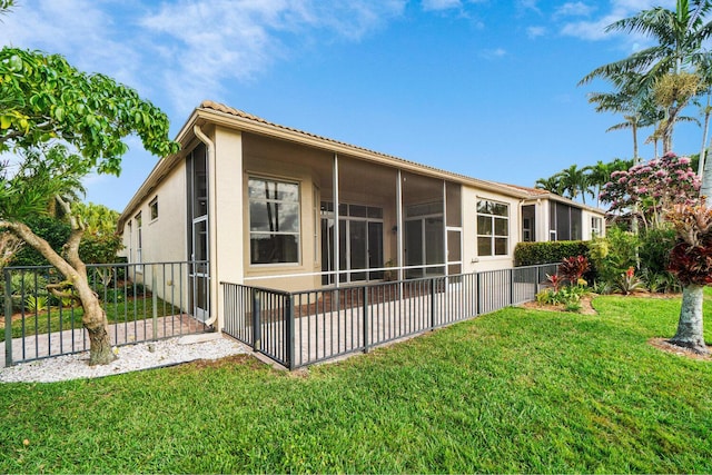 rear view of property with a yard and a sunroom