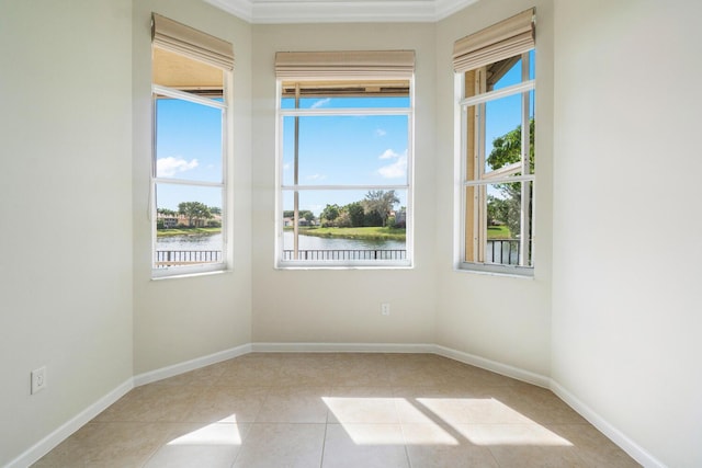 spare room featuring light tile patterned flooring and a water view