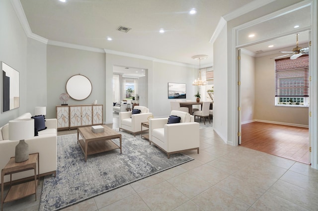 tiled living room featuring crown molding and ceiling fan with notable chandelier