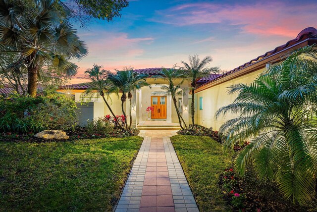 exterior entry at dusk with a yard