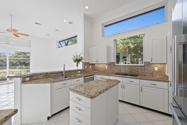 kitchen featuring a kitchen island, sink, white cabinets, dark stone counters, and black electric cooktop