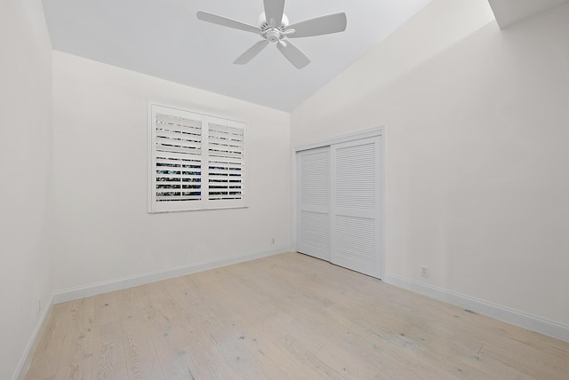 unfurnished bedroom featuring lofted ceiling, light hardwood / wood-style flooring, a closet, and ceiling fan