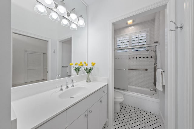 full bathroom featuring vanity, tile patterned flooring, toilet, and combined bath / shower with glass door