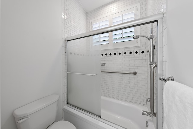 bathroom with enclosed tub / shower combo and toilet