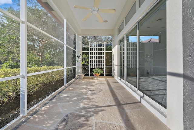 unfurnished sunroom featuring ceiling fan