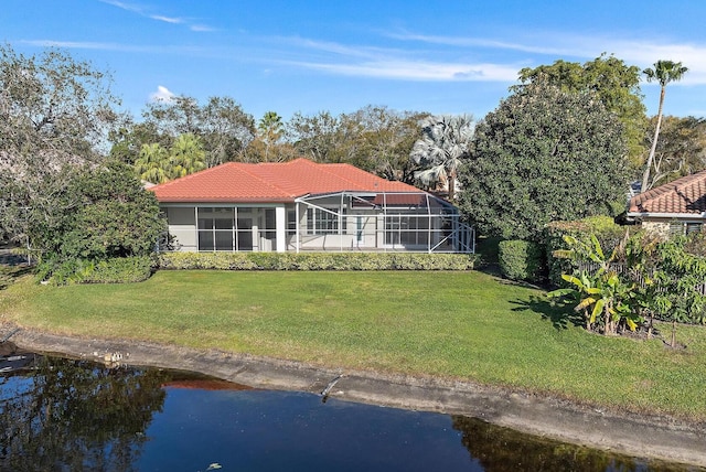 rear view of property with a yard, a lanai, and a water view