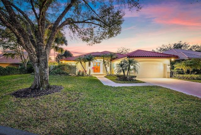 mediterranean / spanish home with a garage and a lawn