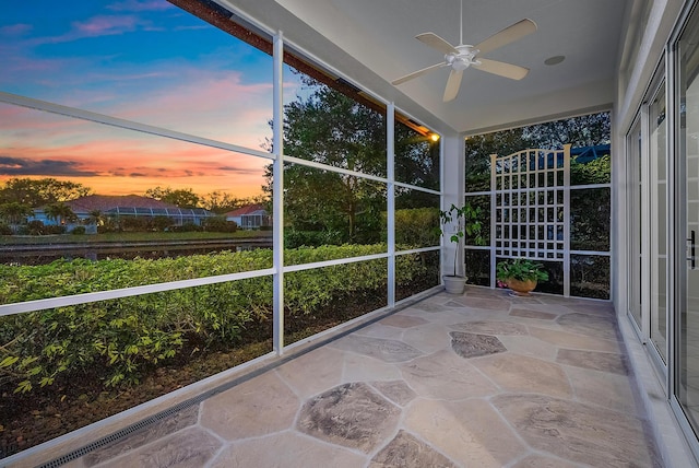 unfurnished sunroom with ceiling fan