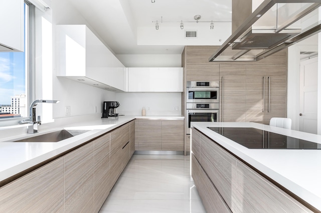 kitchen with double oven, sink, white cabinets, and black electric stovetop