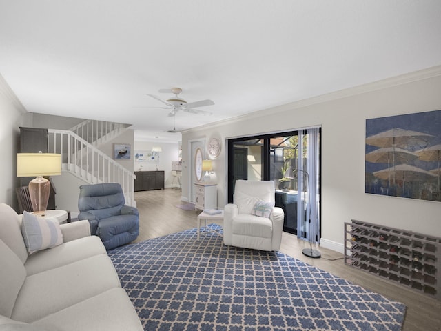 living room featuring hardwood / wood-style flooring, crown molding, and ceiling fan