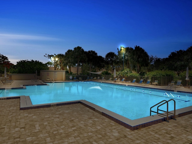 pool at dusk with a patio