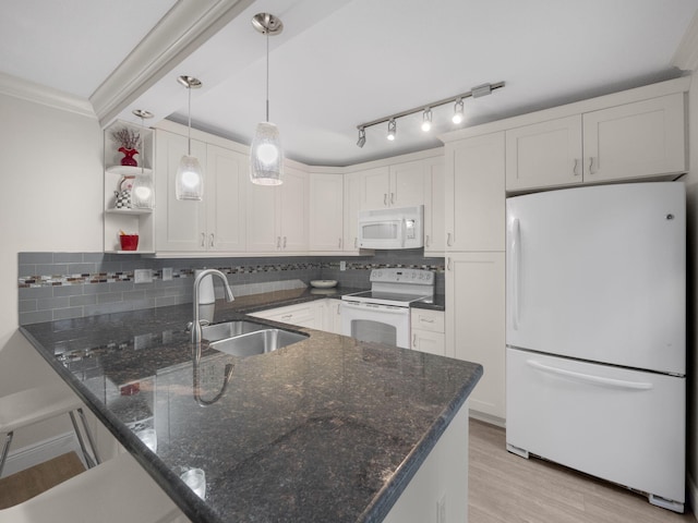 kitchen with sink, white appliances, kitchen peninsula, and white cabinets