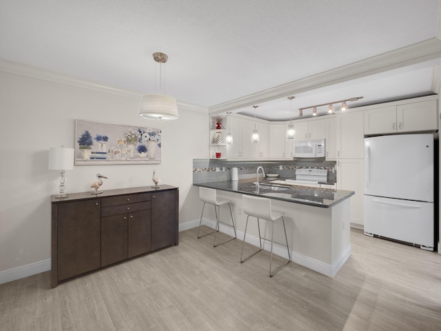 kitchen featuring white cabinetry, white appliances, decorative light fixtures, and kitchen peninsula