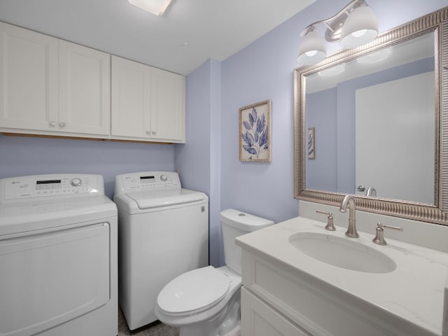 bathroom with vanity, toilet, and washing machine and clothes dryer