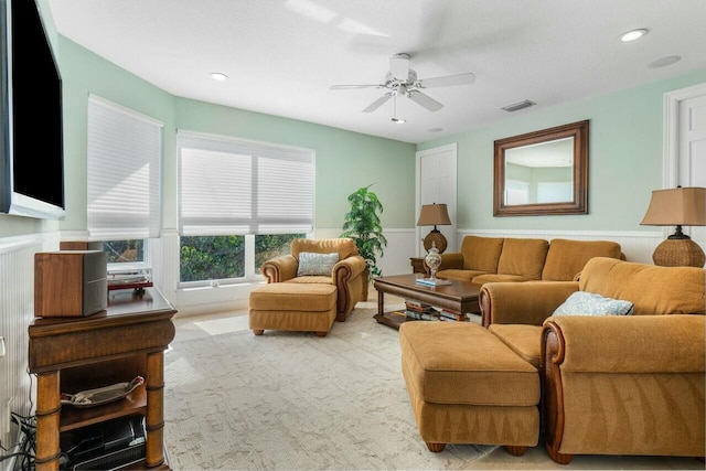 carpeted living room with ceiling fan