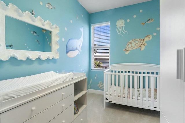 bedroom featuring light carpet and a nursery area