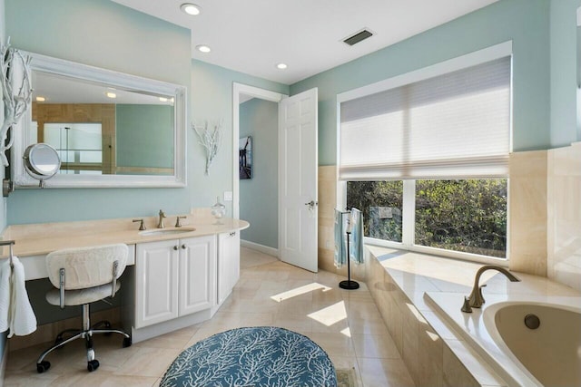 bathroom featuring vanity, tile patterned flooring, and a relaxing tiled tub