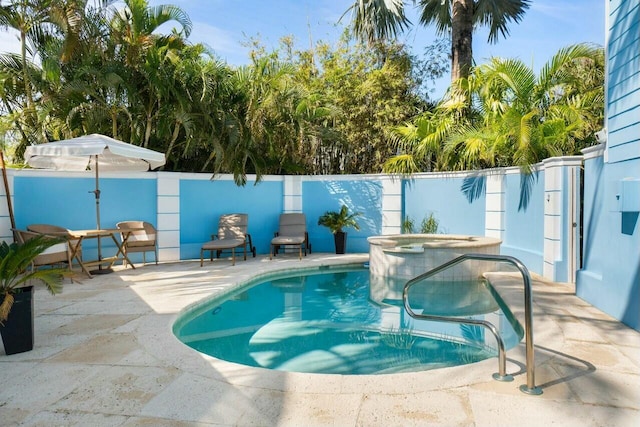 view of swimming pool featuring an in ground hot tub and a patio