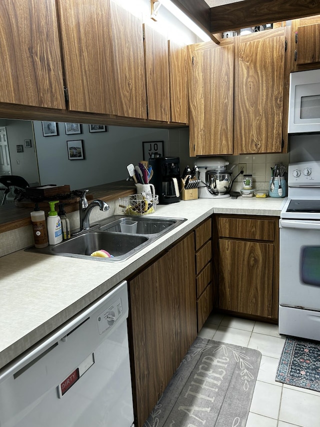 kitchen featuring light tile patterned flooring, white appliances, sink, and decorative backsplash