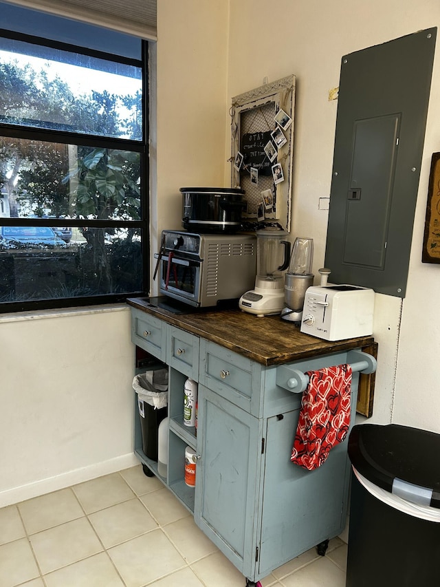 kitchen featuring butcher block counters, light tile patterned floors, and electric panel