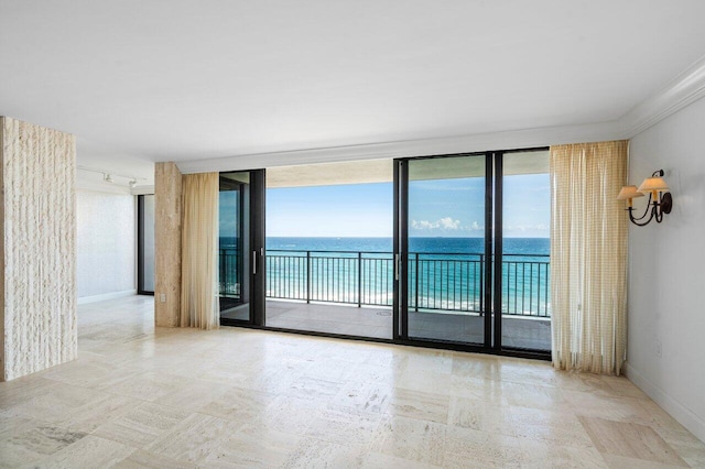 empty room with a water view, expansive windows, and baseboards