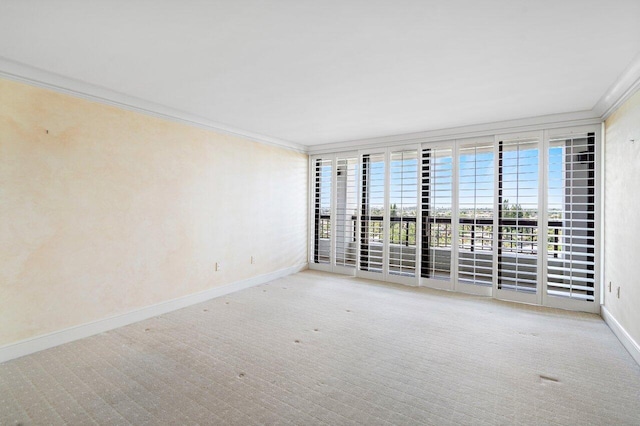 empty room featuring floor to ceiling windows, ornamental molding, light colored carpet, and baseboards