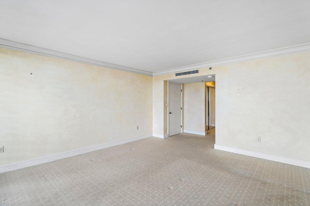 spare room featuring baseboards, visible vents, and crown molding