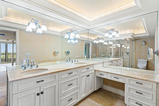 bathroom with ornamental molding, a sink, toilet, and double vanity