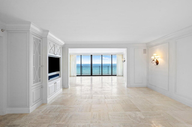 unfurnished living room with crown molding and a decorative wall