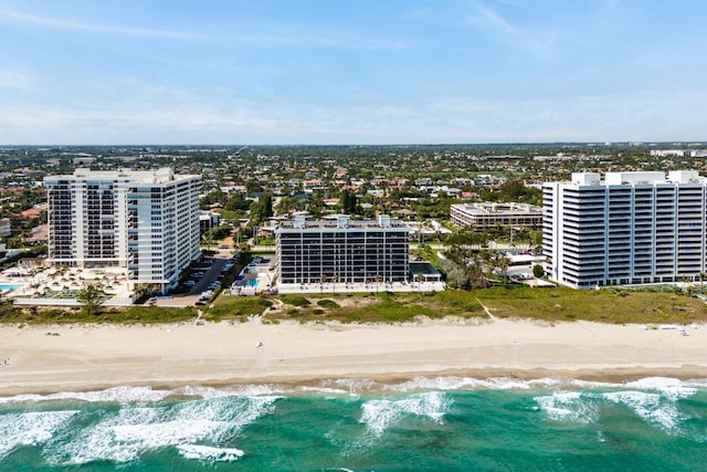 drone / aerial view featuring a view of the beach, a water view, and a view of city