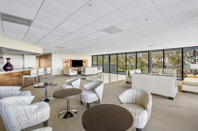 living room featuring a paneled ceiling, carpet, visible vents, and floor to ceiling windows