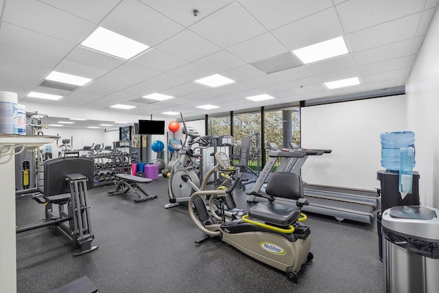 gym with floor to ceiling windows and a drop ceiling